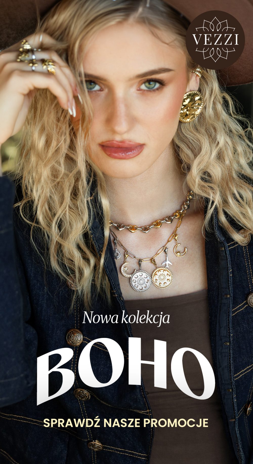 Kobieta w dużych kolczykach, pierścionkach i warstwowych naszyjnikach z zawieszkami. Logo VEZZI i napisy: „Nowa kolekcja BOHO” oraz „Sprawdź nasze promocje”.
