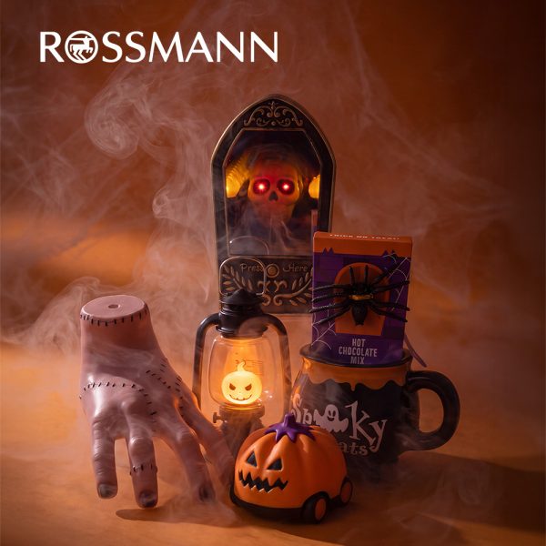 Dekoracje Halloween w Rossmannie: dzwonek z czaszką, sztuczna ręka, latarnia z dynią, pojazd w kształcie dyni oraz kubek z czekoladą do picia.